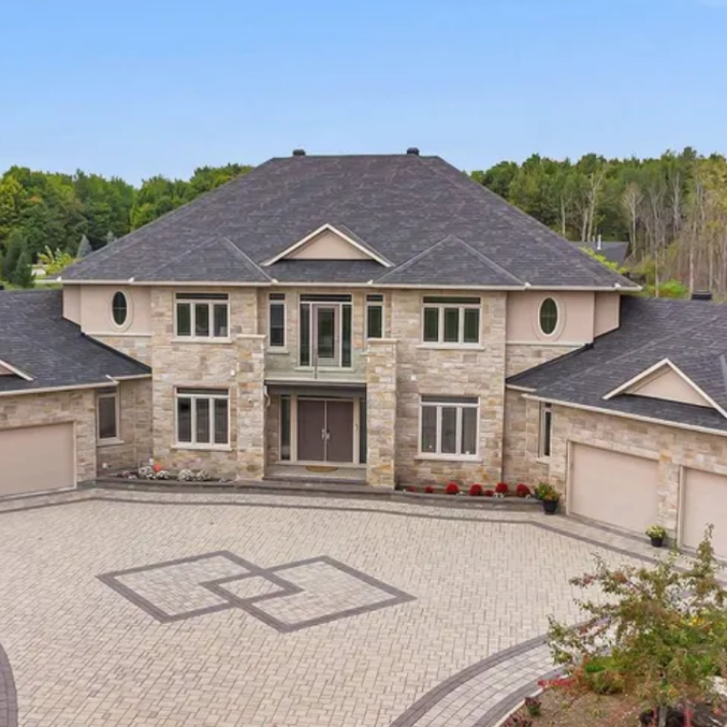 5813 Red Castle Ridge, Ottawa — elegant executive home with brick and stone facade, arched windows, and lush landscaping in a prestigious neighborhood.