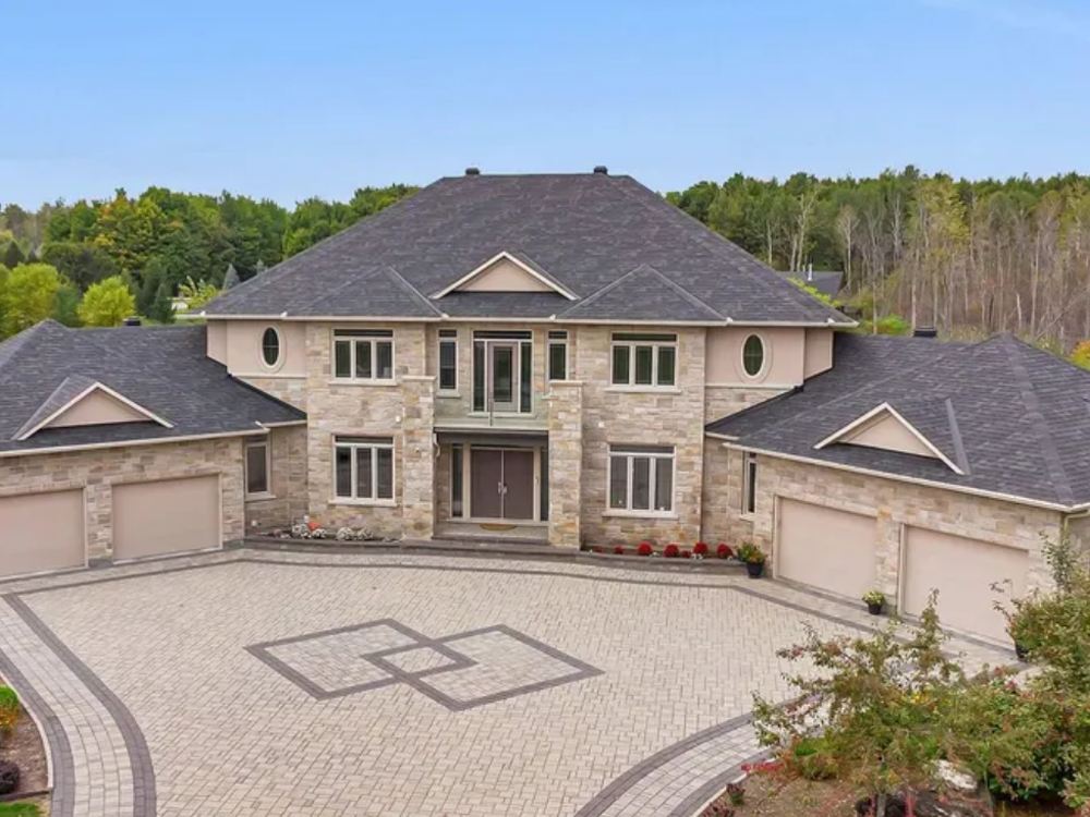 5813 Red Castle Ridge, Ottawa — elegant executive home with brick and stone facade, arched windows, and lush landscaping in a prestigious neighborhood.