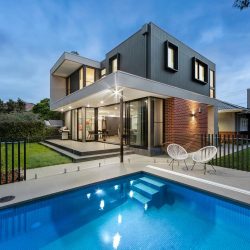 Front view of a modern house with clean architectural lines, large windows, and a minimalist exterior design.