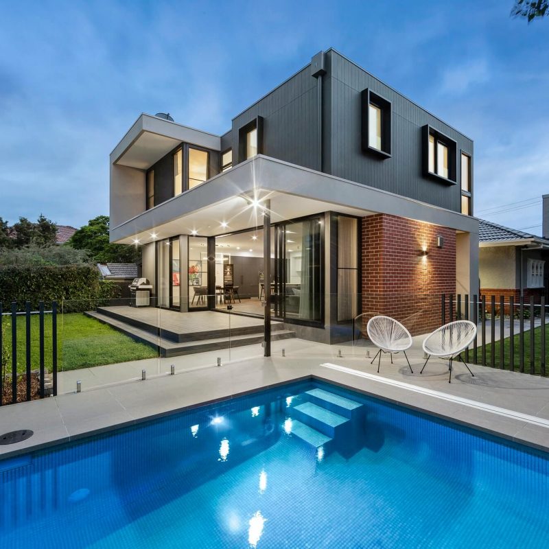 Front view of a modern house with clean architectural lines, large windows, and a minimalist exterior design.