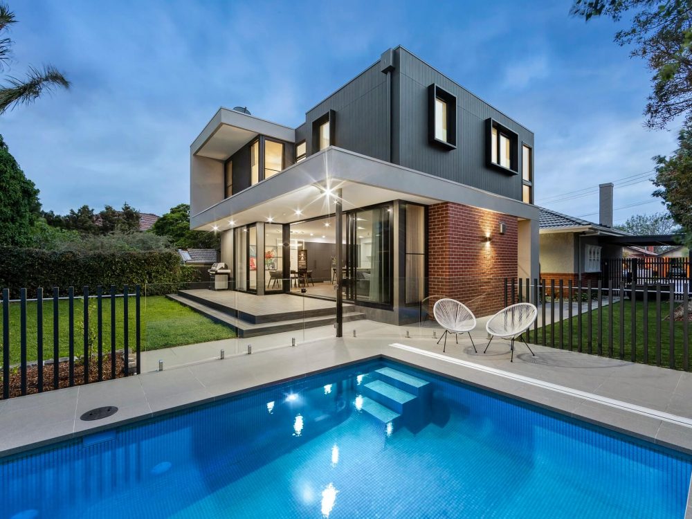 Front view of a modern house with clean architectural lines, large windows, and a minimalist exterior design.